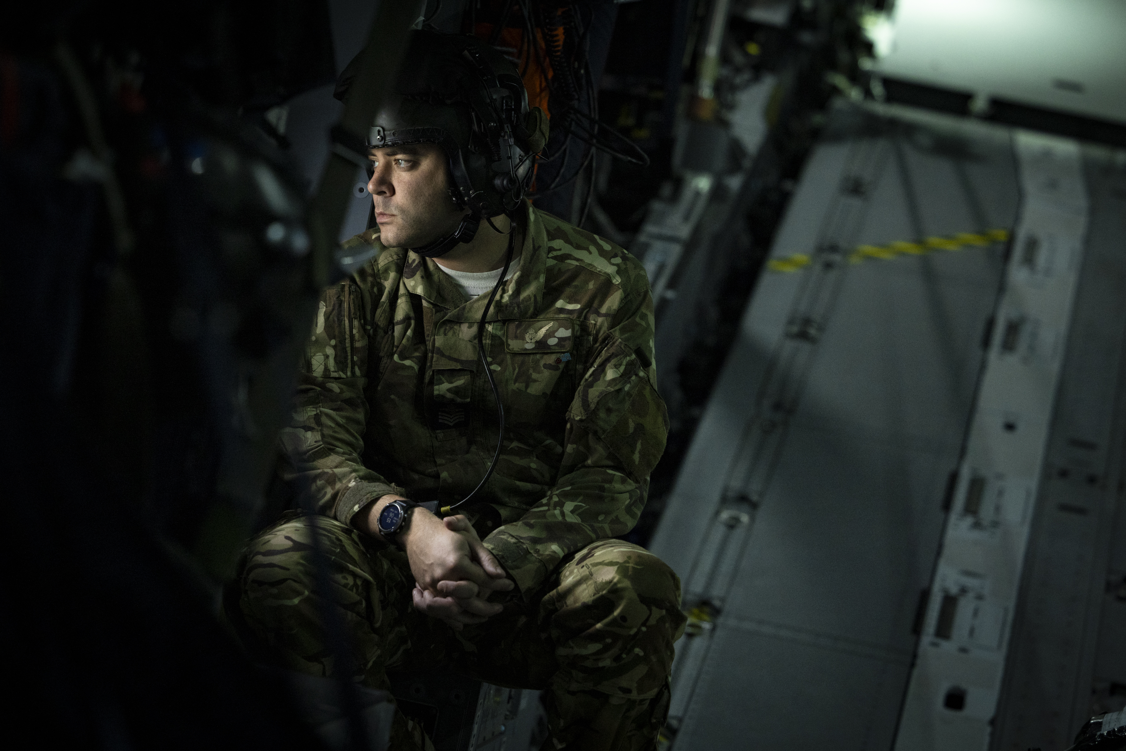 Photo: Image showing Exercise Venture Spirit Atlas C Mk.1 (A400M) Loadmaster seated forward of the closed ramp and door at the rear of the aircraft, while looking out of the Starboard parachuting door window
